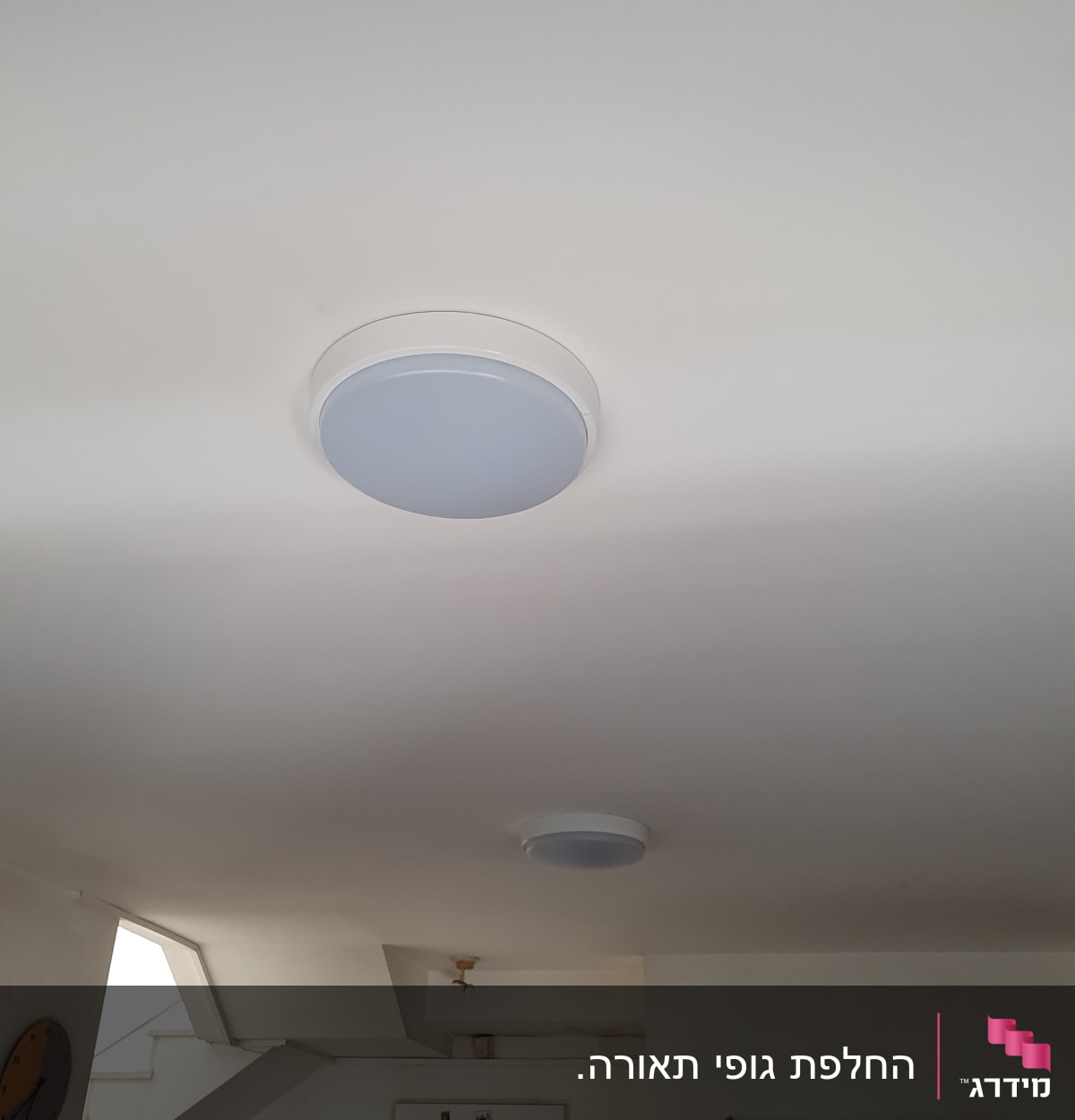 שני גופי תאורה עגולים מותקנים בתקרה לבנה